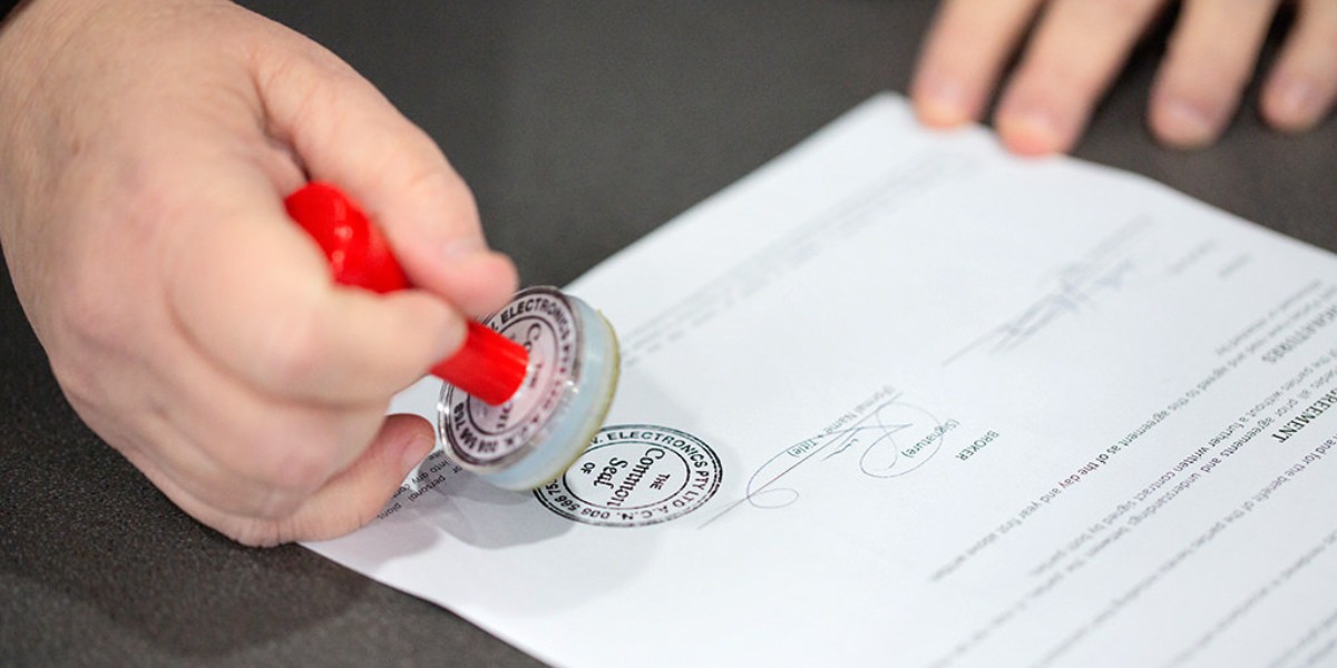 Hand stamping a red common seal on a certified translation document