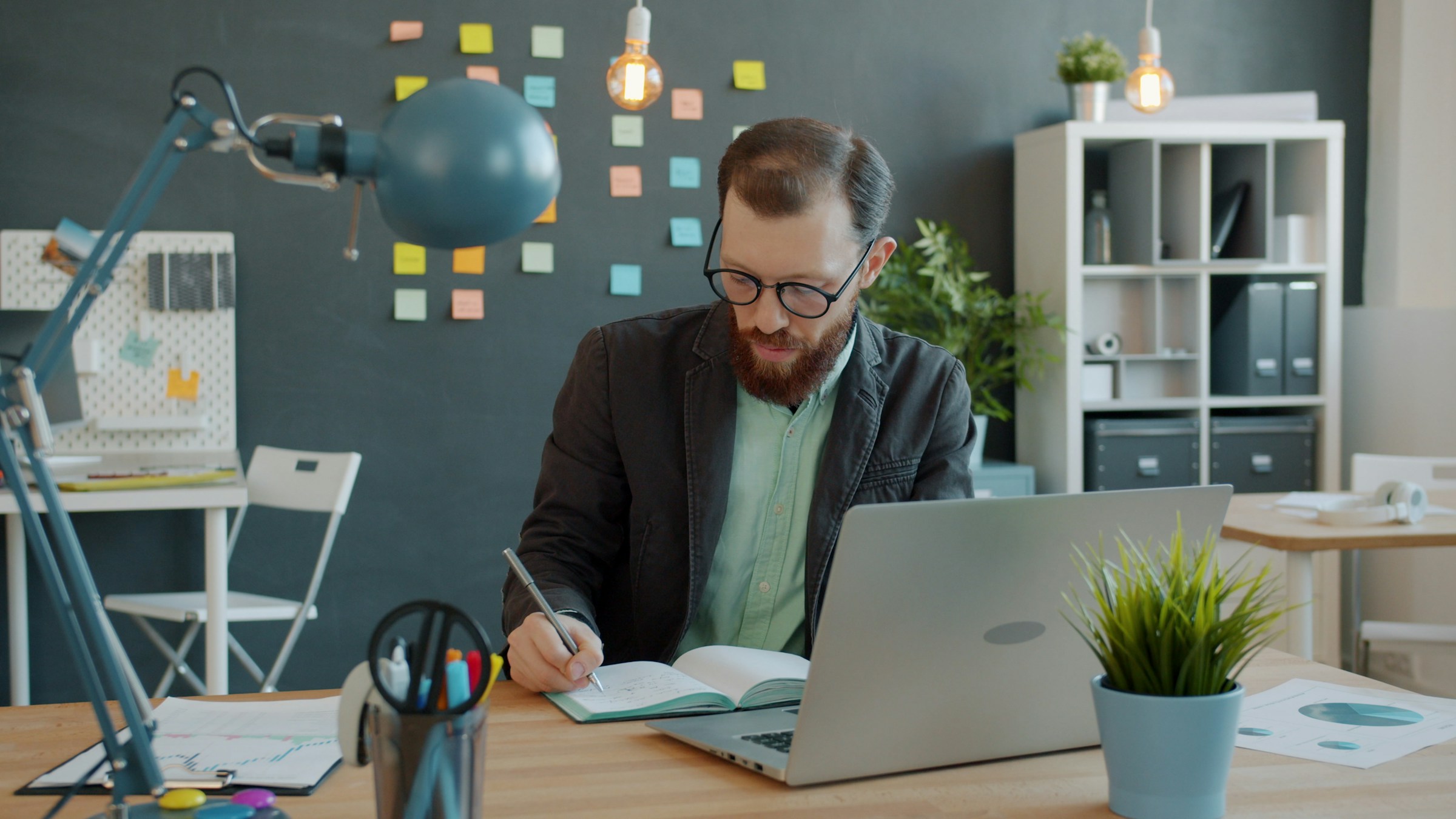 Man in glasses reviewing documents at an office desk while comparing translation prices